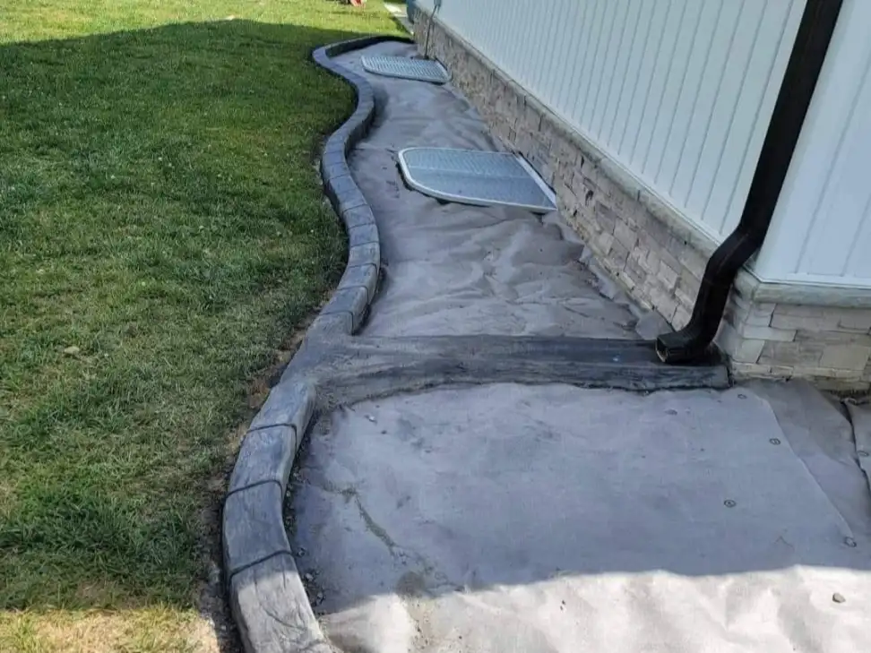 Finished front yard decorative concrete curbing around a tree bed