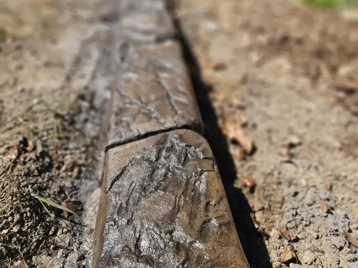 Custom concrete downspout drainage feature with river rock