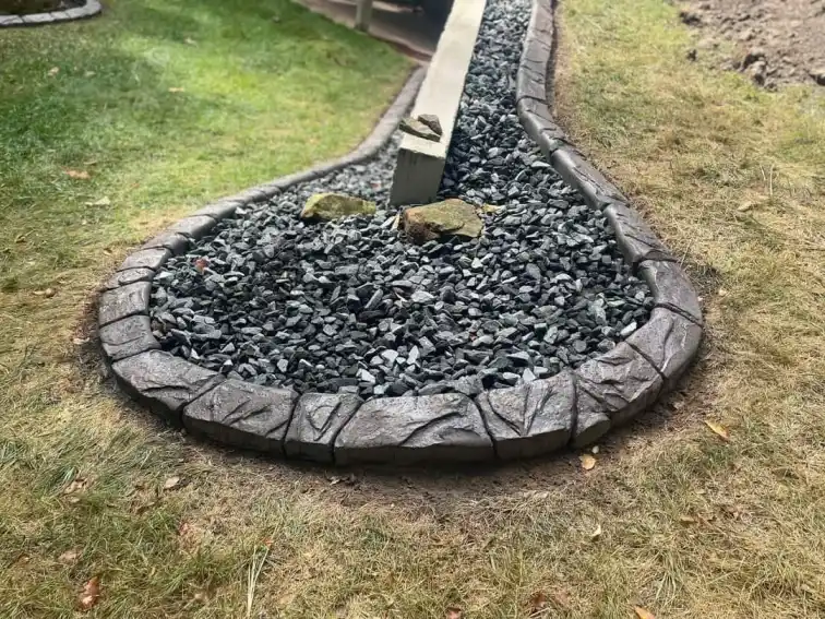 Circular stamped concrete curb around a stone-covered tree bed