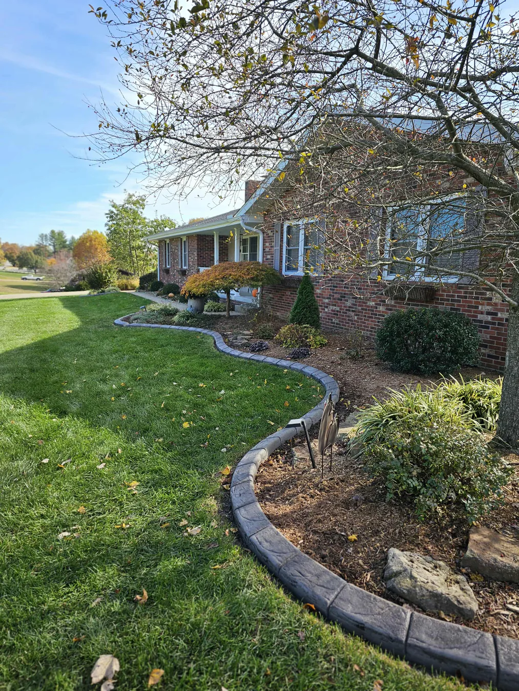 Finished concrete landscape edging along a brick home