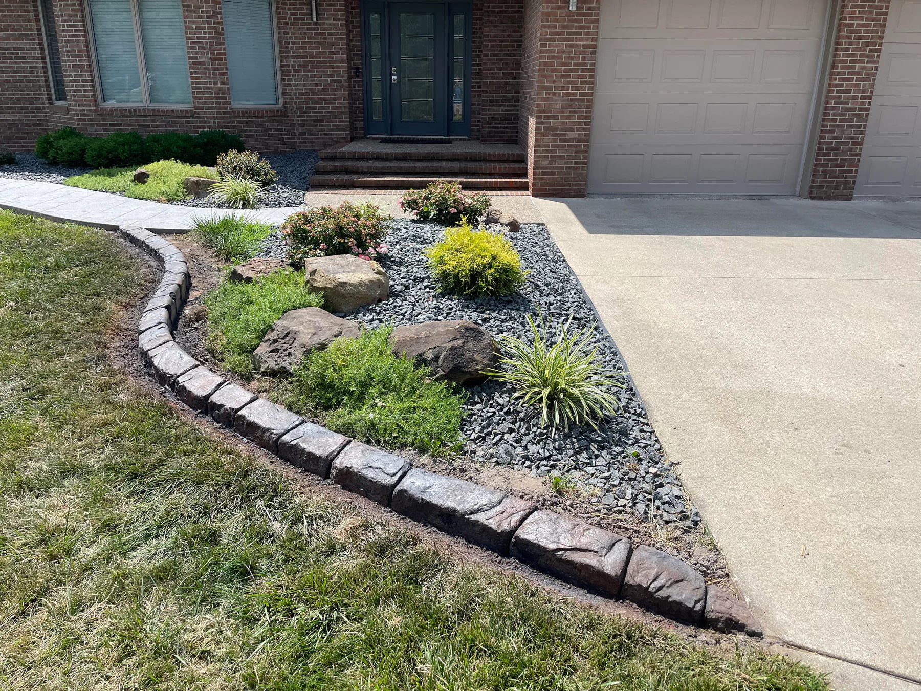 Curved decorative concrete border beside a front walkway