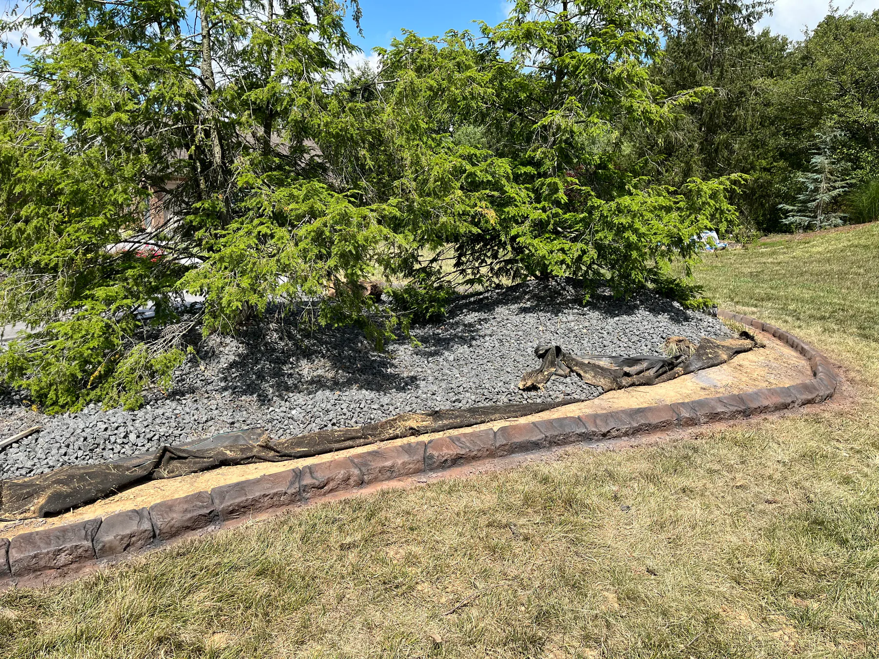 Stone-look concrete curbing wrapping a large landscape island