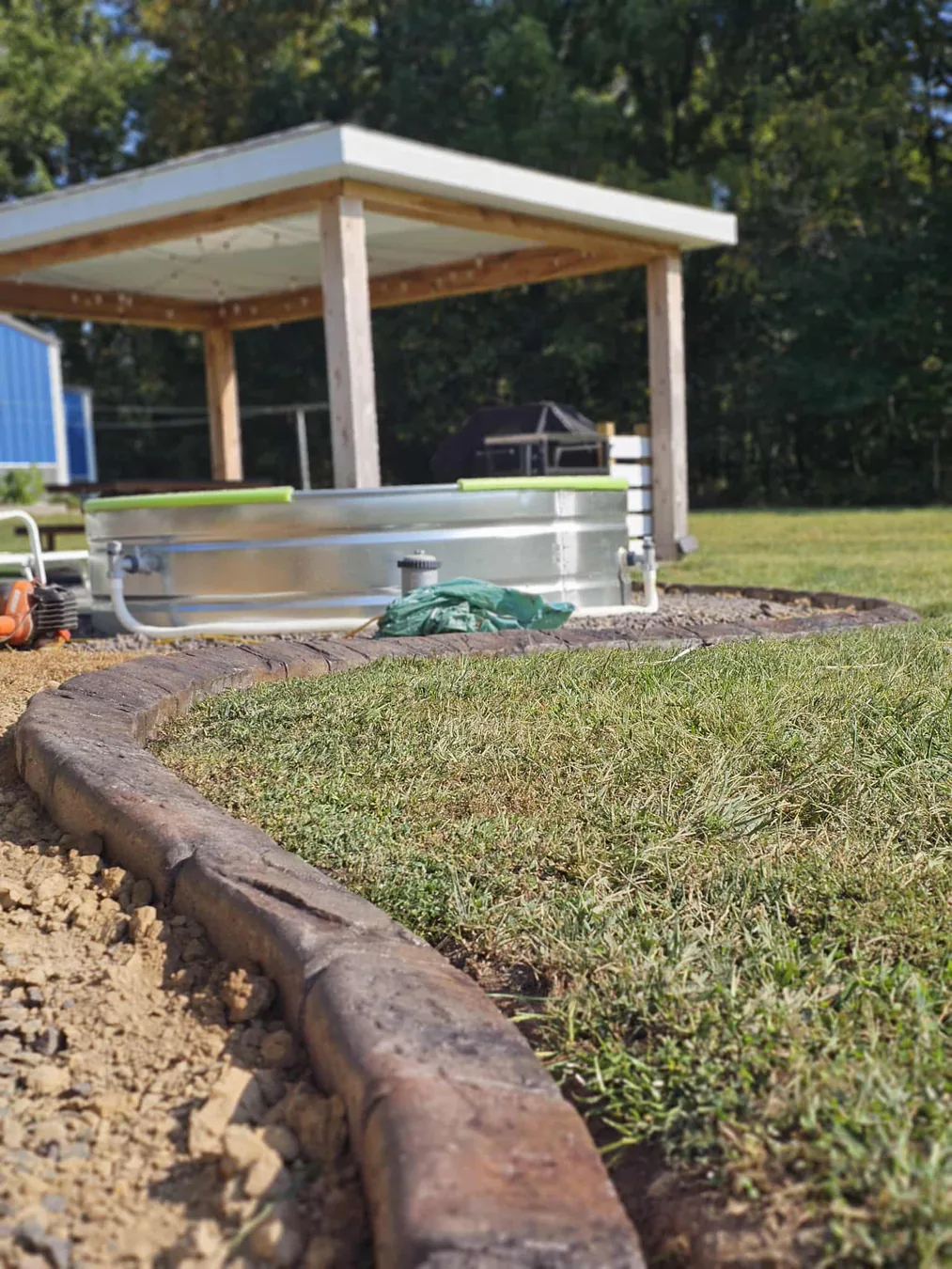 Concrete curbing installation in progress around a planting bed