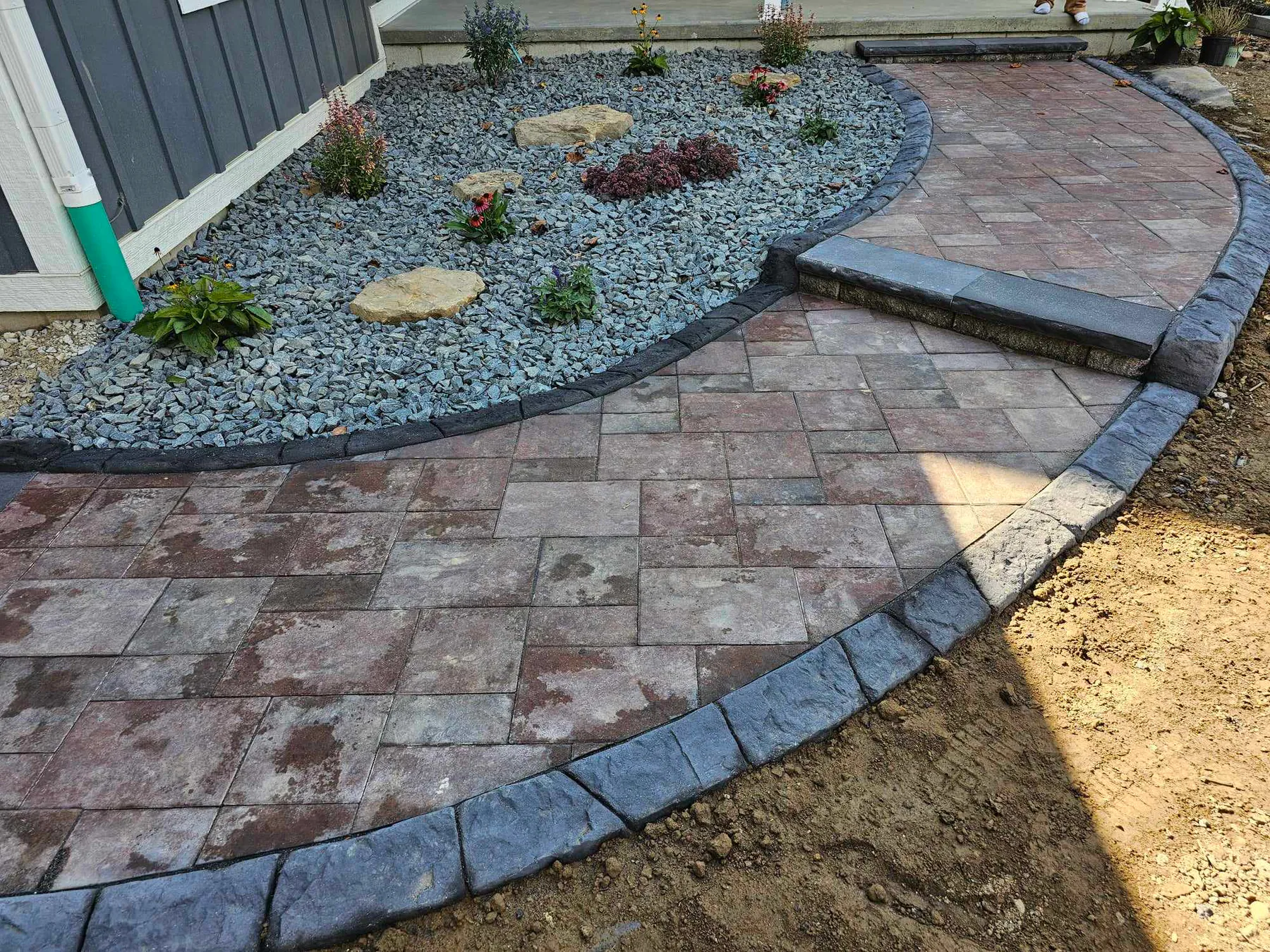 Curved stamped concrete border meeting a patio edge