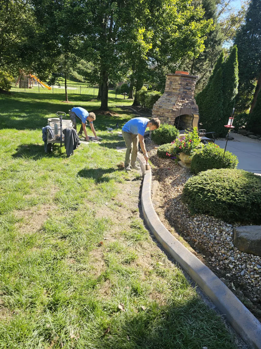 Crew forming a continuous curb along a brick home