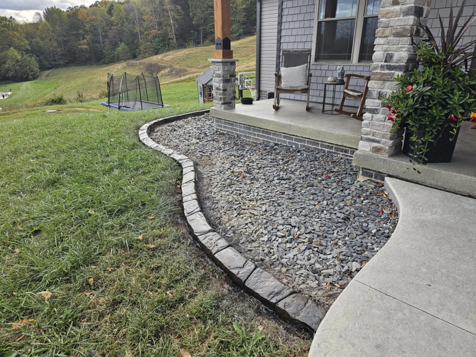 Finished gray concrete curbing along a brick residence