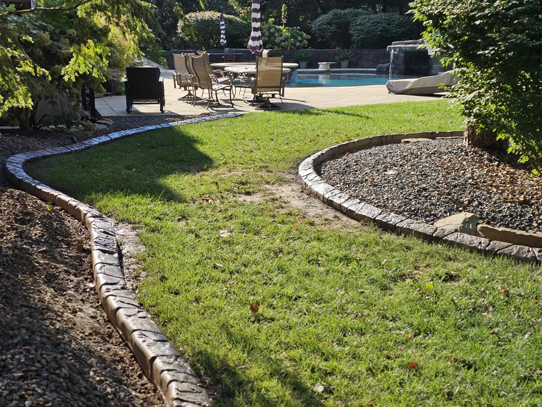 Decorative concrete edging defining a poolside landscape