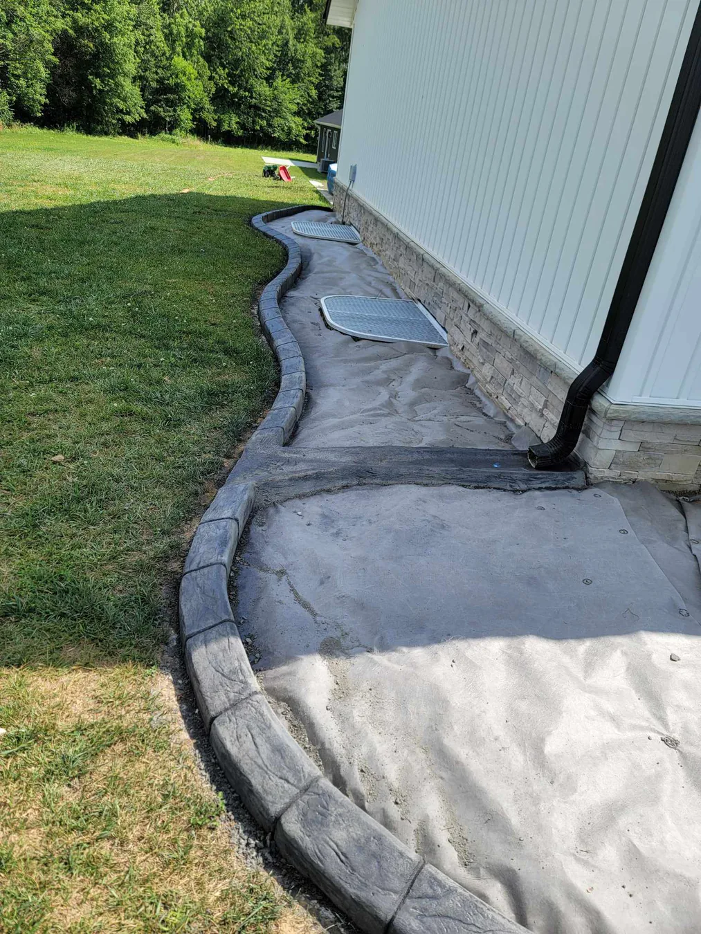 Fresh stamped patio border beside a white residence