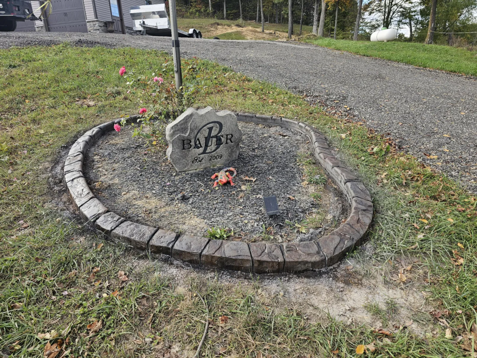 Custom decorative concrete border formed around a residential monument stone