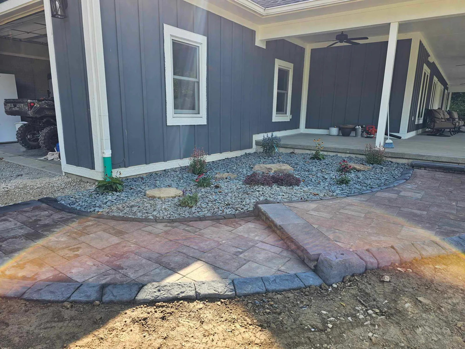 Finished stamped concrete patio with a coordinated rock landscape bed