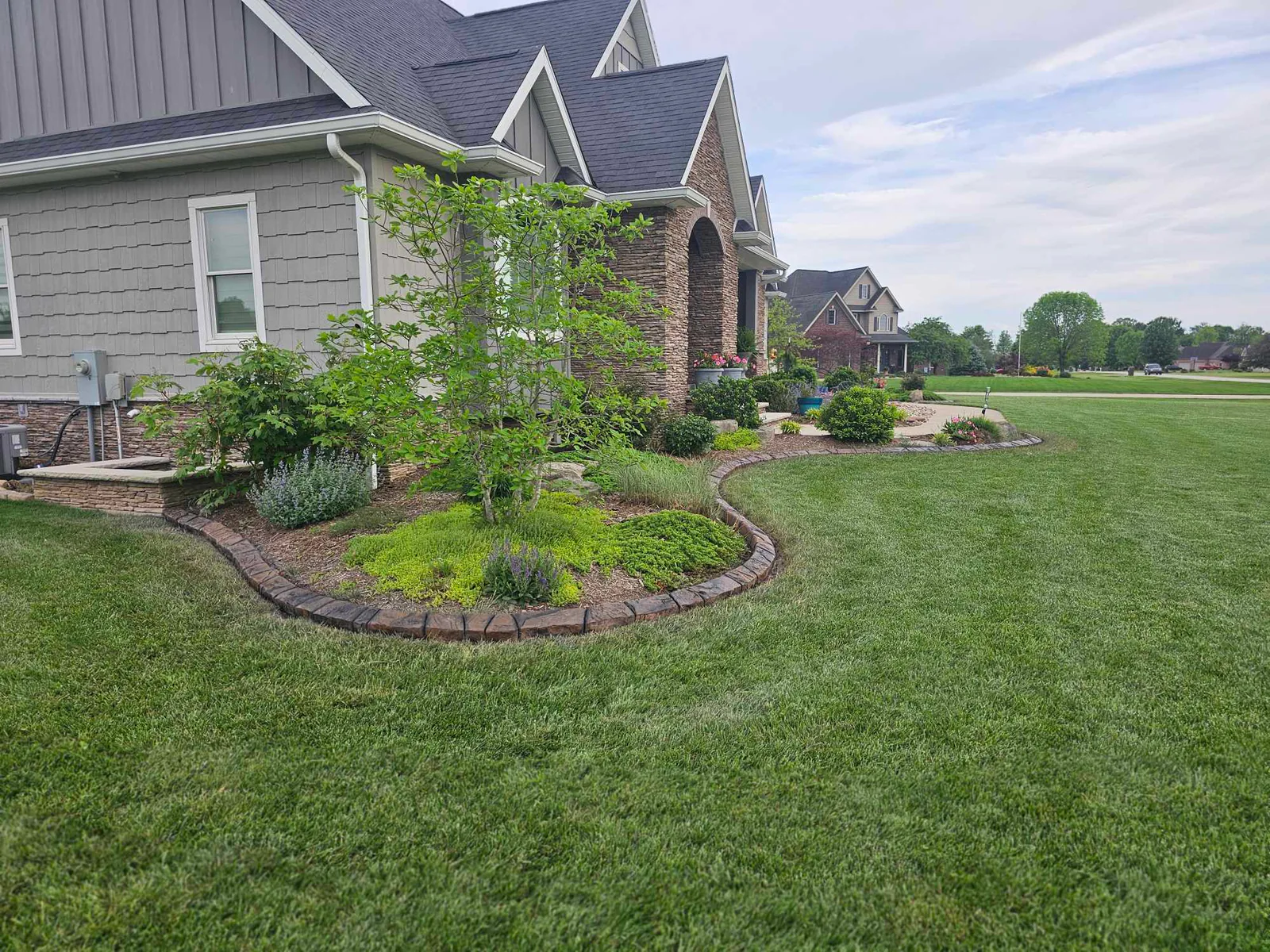 Maintained front landscape beds with clean lawn and concrete borders